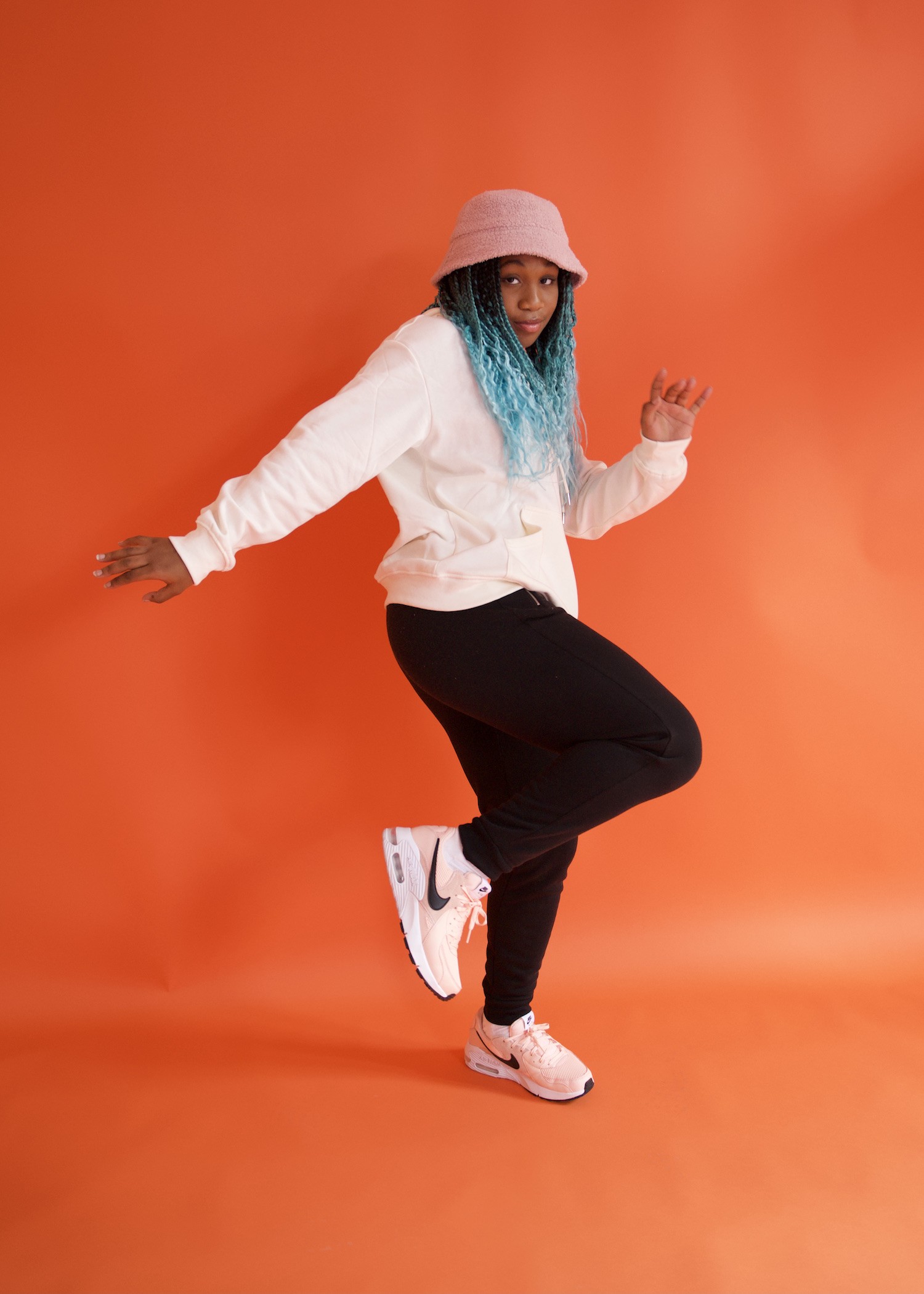 Hip-hop dancer in a pink bucket hat and white streetwear